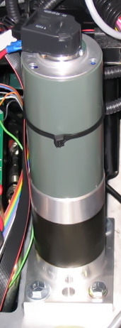 Industrial servomotor: The grey–green cylinder is a brush-type DC motor, the black section at the bottom contains a planetary reduction gearset, and the black object on top of the motor is the optical rotary encoder for position feedback.