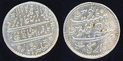 Silver rupee using Mughal conventions, but minted by the British East India Company Madras Presidency between 1817 and 1835. On rupees, the side that carries the name of the ruler is considered the obverse.