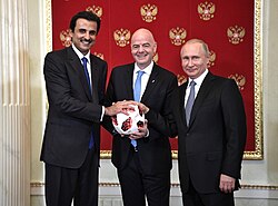 Russian President Vladimir Putin handing over the symbolic relay baton for the hosting rights of the 2022 FIFA World Cup to Qatar's Emir Tamim bin Hamad Al Thani in June 2018.
