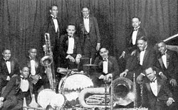 Fletcher Henderson (middle) with his orchestra in 1925. Coleman Hawkins is sitting on the floor to the extreme left with Louis Armstrong above him to the right.