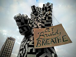 The statue holding a placard for a clean air protest, organised by the Bristol Green Party, 2016.