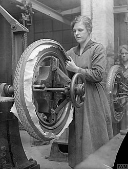 A factory worker producing a vehicle tire using natural rubber, September 1918