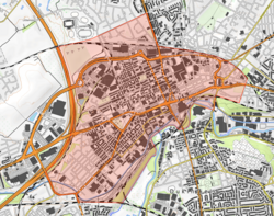 An OS map of the area, a rough cuboid of which is shaded red to show roughly the boundaries of Ashton. To the left this is a large road, and to the bottom a river.