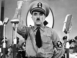 Comedian Charlie Chaplin impersonating Hitler for comic effect in the satirical film The Great Dictator (1940)