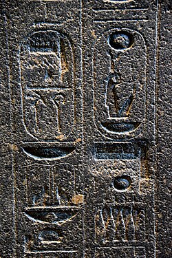Hieroglyphs on the backpillar of Amenhotep 's statue. There are 2 places where Akhenaten erased the name Amun, later restored on a deeper surface. The British Museum, London