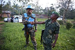 An Indian Army peacekeeper and an FARDC soldier shake hands and encourage each other