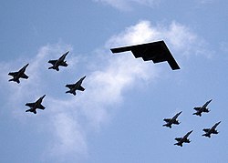 A B-2 in formation flight with eight U.S. Navy F/A-18 Hornets and Super Hornets