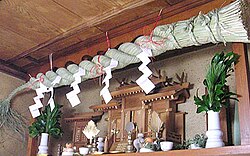 A kamidana displaying a shimenawa and shide