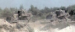 IDF Caterpillar D9N armored bulldozers destroy a Hezbollah bunker.