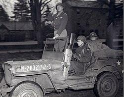 Major General Walter M. Robertson (back seat), commanding the 2nd Infantry Division, with Lieutenant General Patton pass in review of elements of Patton's Third Army in April 1944, prior to the Normandy invasion in June