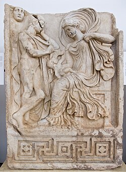 Greek relief from Aphrodisias, depicting a Roman-influenced Aphrodite sitting on a throne holding an infant while the shepherd Anchises stands beside her.