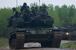 Soldiers from 2 Canadian Mechanized Brigade Group sit atop a Leopard 2A4 tank during a military exercise at CFB Wainwright, 2017