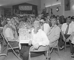 Highland Park Optimist Club wearing smog-gas masks at banquet, Los Angeles, circa 1954