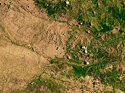 A satellite image of the border between Haiti (left) and the Dominican Republic (right), highlighting the deforestation on the Haitian side