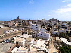 Deux Mamelles seen from afar, with the African Renaissance Monument on the left and Les Mamelles Lighthouse on the right