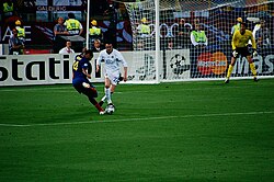 Henry taking on Manchester United defender John O'Shea. In his prime, Henry would often drift out to the left wing position and run towards goal.[114]