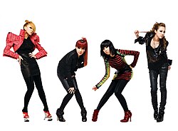 2NE1 striking a pose in front of a drawn set