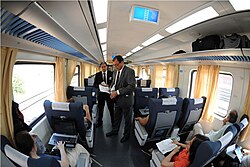 Staff checking tickets in a pullman class carriage on a long-distance train