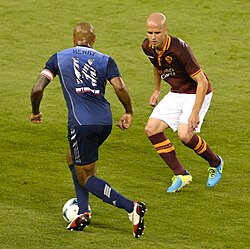 Bradley defending for Roma against Thierry Henry of MLS All-Stars in 2013.
