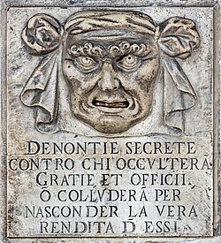 A "Lion's Mouth" postbox for anonymous denunciations at the Doge's Palace in Venice, Italy. Text translation: "Secret denunciations against anyone who will conceal favors and services or will collude to hide the true revenue from them."