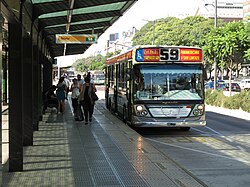 Passengers arriving to a Buenos Aires Metrobus bus stop. Buenos Aires autobus lines can be easily recognized by their colorful designs .