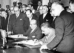 Egyptian president Gamal Abdel Nasser (seated right) and Syrian president Shukri al-Quwatli sign the accord to form the United Arab Republic in 1958. The political union briefly represented both states and was used as the name of Egypt following Syria's withdrawal in 1961.