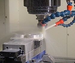 A milling machine in operation, including coolant hoses