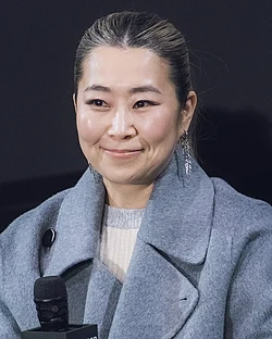 Maggie Kang directly facing the camera while seated