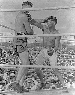 Willard (left) taking a punch to the chin from Jack Dempsey (right).
