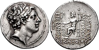 Silver coin of king Antiochus IV. Reverse shows seated Zeus holding Nike and scepter. Greek inscription reads: ΒΑΣΙΛΕΩΣ ΑΝΤΙΟΧΟΥ ΝΙΚΗΦΟΡΟΥ ΘΕΟΥ ΕΠΙΦΑΝΟΥΣ, Basileōs Antiochou Nikēphorou Theou Epiphanous, "of victorious god manifest king Antiochus".