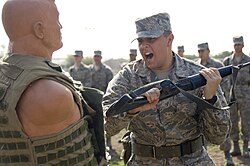 U.S. Air Force trainee demonstrating a butt stroke on a strike dummy as part of Basic Military Training