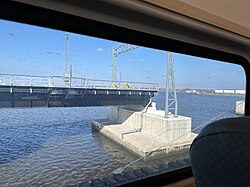 Portion of the new bridge under construction, as seen in January 2025 from a train on the existing bridge