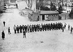 Prisoners guarded by SA men line up in the yard of Oranienburg, 6 April 1933