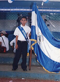 Primary school student in Nicaragua holding the national flag