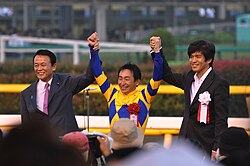 Norihiro at the awards ceremony following the 76th Tokyo Yushun (2009). From left to right: Taro Aso, Norihiro Yokoyama, and Koichi Sato