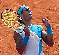 Nadal wearing his signature Nike sleeveless shirt at the French Open in 2007, while holding his Babolat racquet