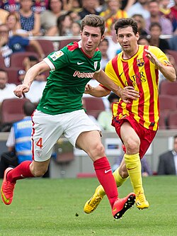 Aymeric Laporte of Athletic and Lionel Messi of Barcelona in the teams' league meeting on 13 September 2014