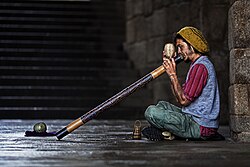 Didgeridoo player entertaining passers by in the street