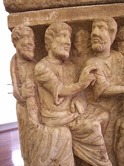 Detail of the earliest known artwork of the Trinity, the Dogmatic or Trinity Sarcophagus, c. 350 (Vatican Museums). Three similar figures, representing the Trinity, are involved in the creation of Eve, whose much smaller figure is cut off at lower right; to her right, Adam lies on the ground.[85]