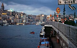 A view of the fourth Galata Bridge (1912–1992) in 1966, with the restoration works (1965–1967)[105] of the conical roof of Galata Tower (the previous one was removed in the 19th century)[105][106][107][f] visible at left.