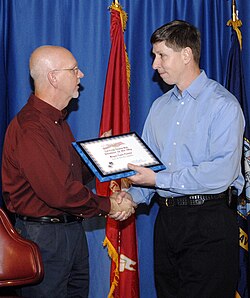 Enid Mayor Ernie Currier receives a certificate of induction as Vance Air Force base's newest Partner in the Sky