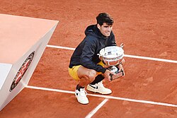 Alcaraz holding the Coupe des Mousquetaires following the men's singles final at the 2024 French Open