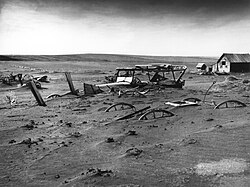 Buried machinery in a barn lot; South Dakota, May 1936. The Dust Bowl on the Great Plains coincided with the Great Depression.[212]