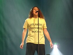 Weird Al wearing his "Atlantic Records Sucks" shirt during a performance of "You're Pitiful", in 2007, at the Ohio State Fair