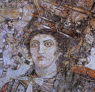 A mosaic from Thmuis (Mendes), Egypt, created by the Hellenistic artist Sophilos (signature) in about 200 BC, now in the Greco-Roman Museum in Alexandria, Egypt; the woman depicted is Queen Berenice II (who ruled jointly with her husband Ptolemy III Euergetes) as the personification of Alexandria, with her crown showing a ship's prow, while she sports an anchor-shaped brooch for her robes, symbols of the Ptolemaic Kingdom's naval prowess and successes in the Mediterranean Sea.[30]