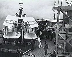 A Seagull III amphibian being manoeuvred towards the hangar hatch following recovery