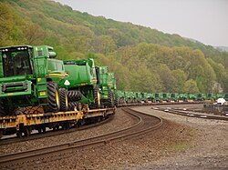 John Deere Combine harvesters being transported by railway on goods wagons in Tyrone, Pennsylvania, in the United States