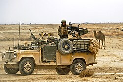 UK service members of the Royal Air Force Regiment stop on a road while conducting a combat mission near Kandahar Airfield, 2010