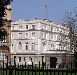 Photograph of the white building with a Union flag flying over it