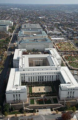 Aerial view of House of Representatives office buildings complex, looking east on the south side of the U.S. Capitol. Front to back: Rayburn Building (1962-1965), Longworth Building (1930-1933), and the Cannon Building (1904-1908). Further east and behind the Cannon Building is the James Madison Memorial Building (built 1971-1980, part of the adjacent Library of Congress complex) (2015)